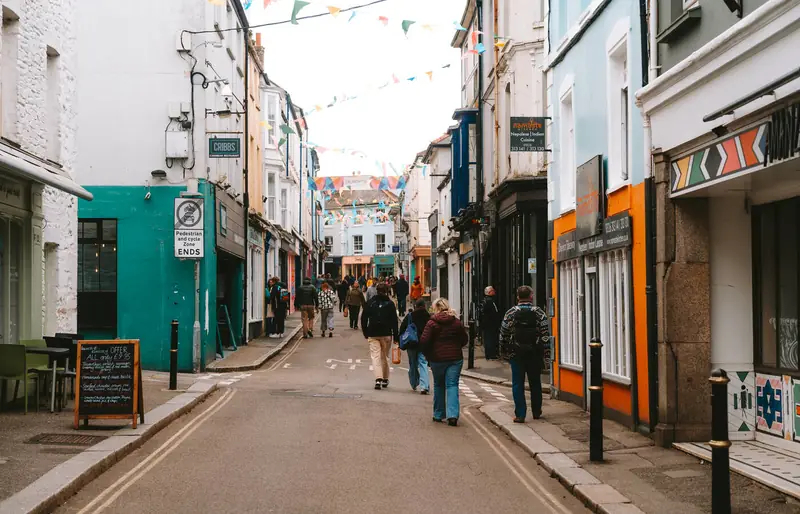 Shoppers on a colourful street in Falmouth town centre