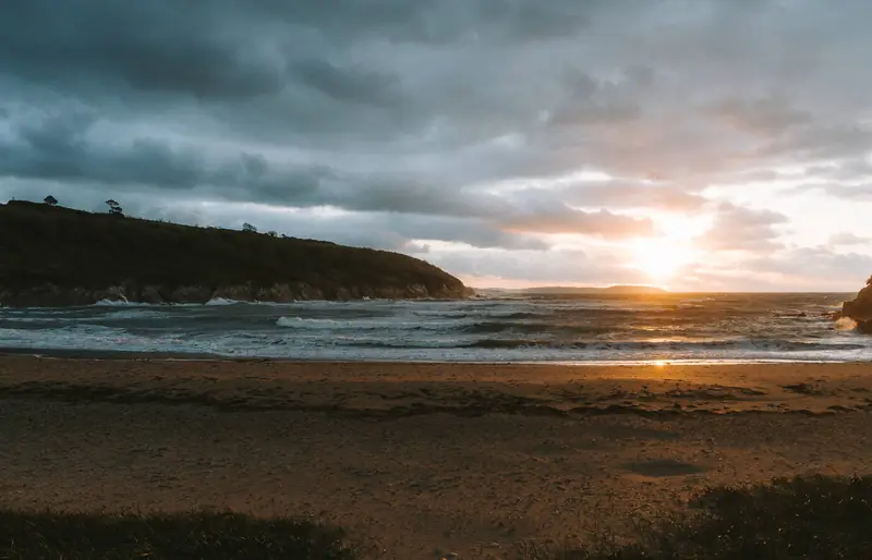 Maenporth Beach at dusk with the headland behind