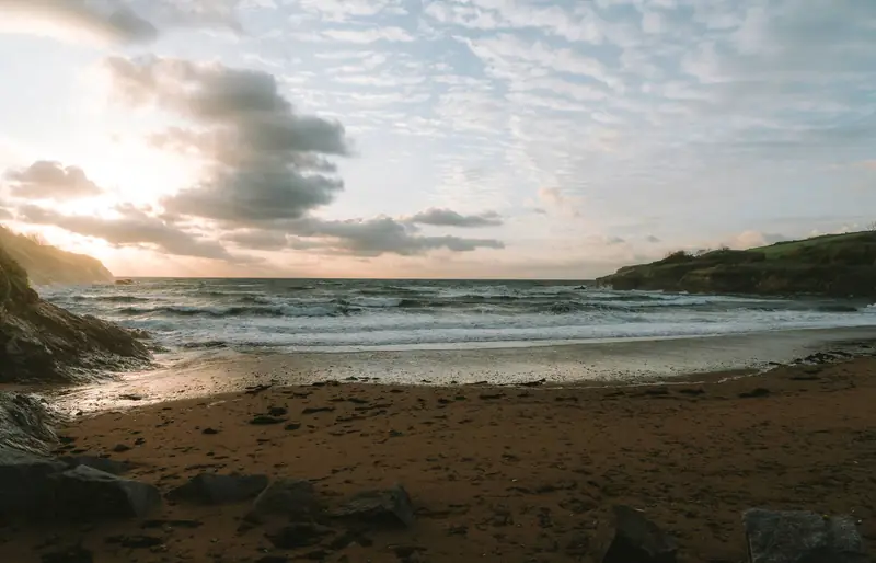Waves on Maenporth Beach under an evening sky