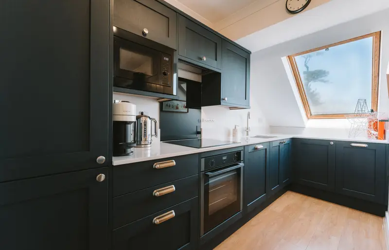 Navy fitted kitchen with oven, microwave and skylight