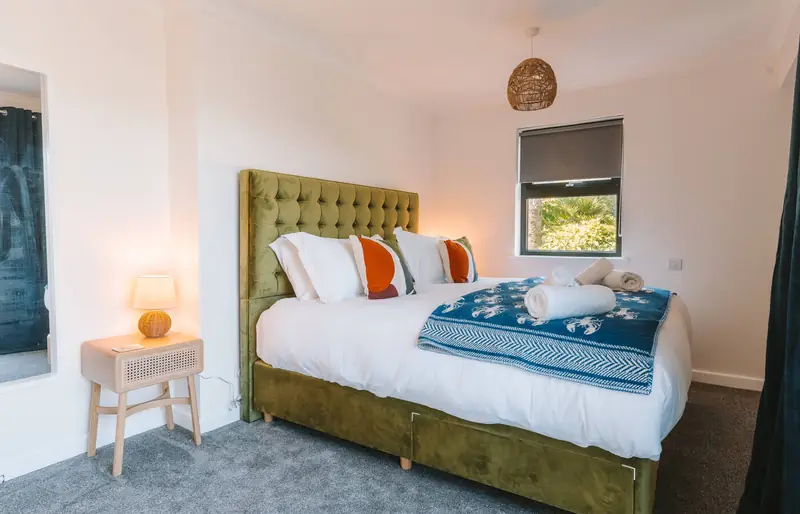 Main bedroom with king-size bed and green headboard