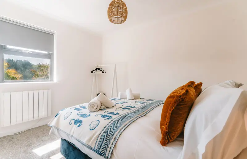 Second bedroom with bed and garden view window